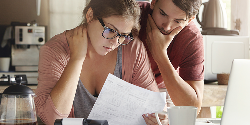 Couple looking at computer with paperwork
